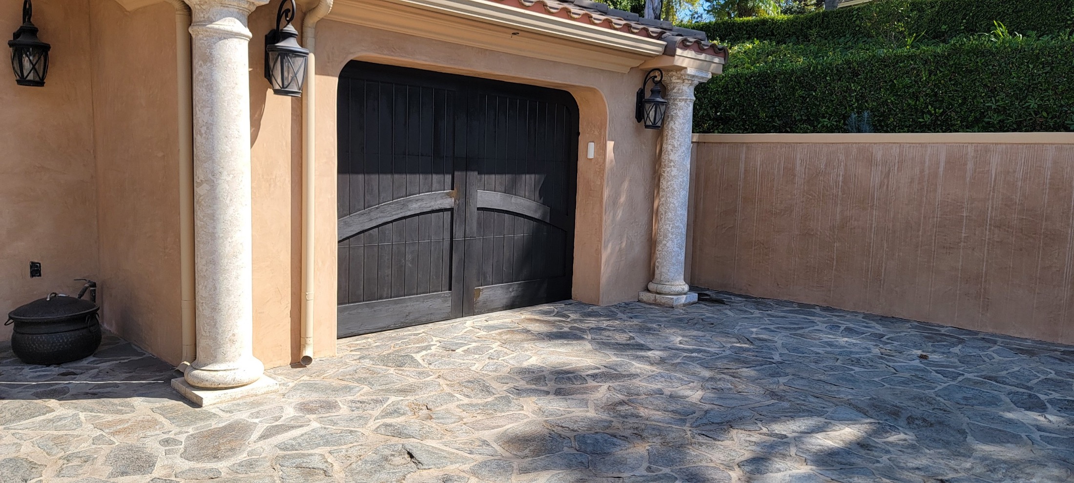 Garage door detail with stone paving and stucco exterior.