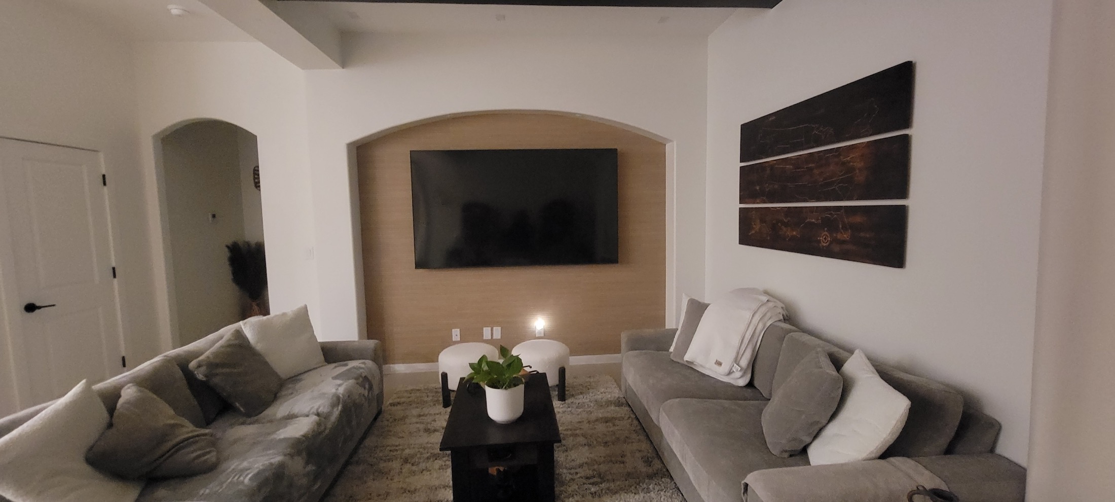 Finished living room remodel with custom media wall and updated seating.